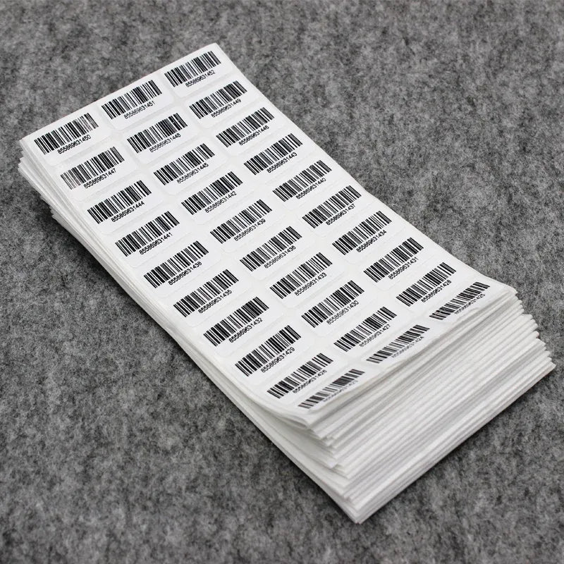 Stack of barcode adhesive number stickers, black barcodes and digits on white labels.