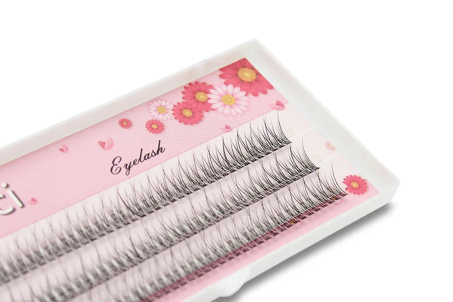 Tray of black, flared 3D mink individual eyelash extension clusters on a floral pink background.