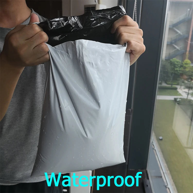 Waterproof plastic self-adhesive poly mailer bag, held up in dark gray