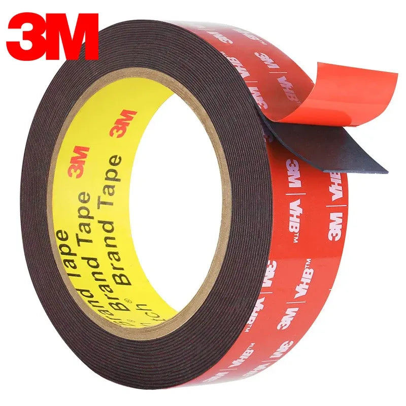 Dark double-sided foam tape roll with red backing and cut tape tail