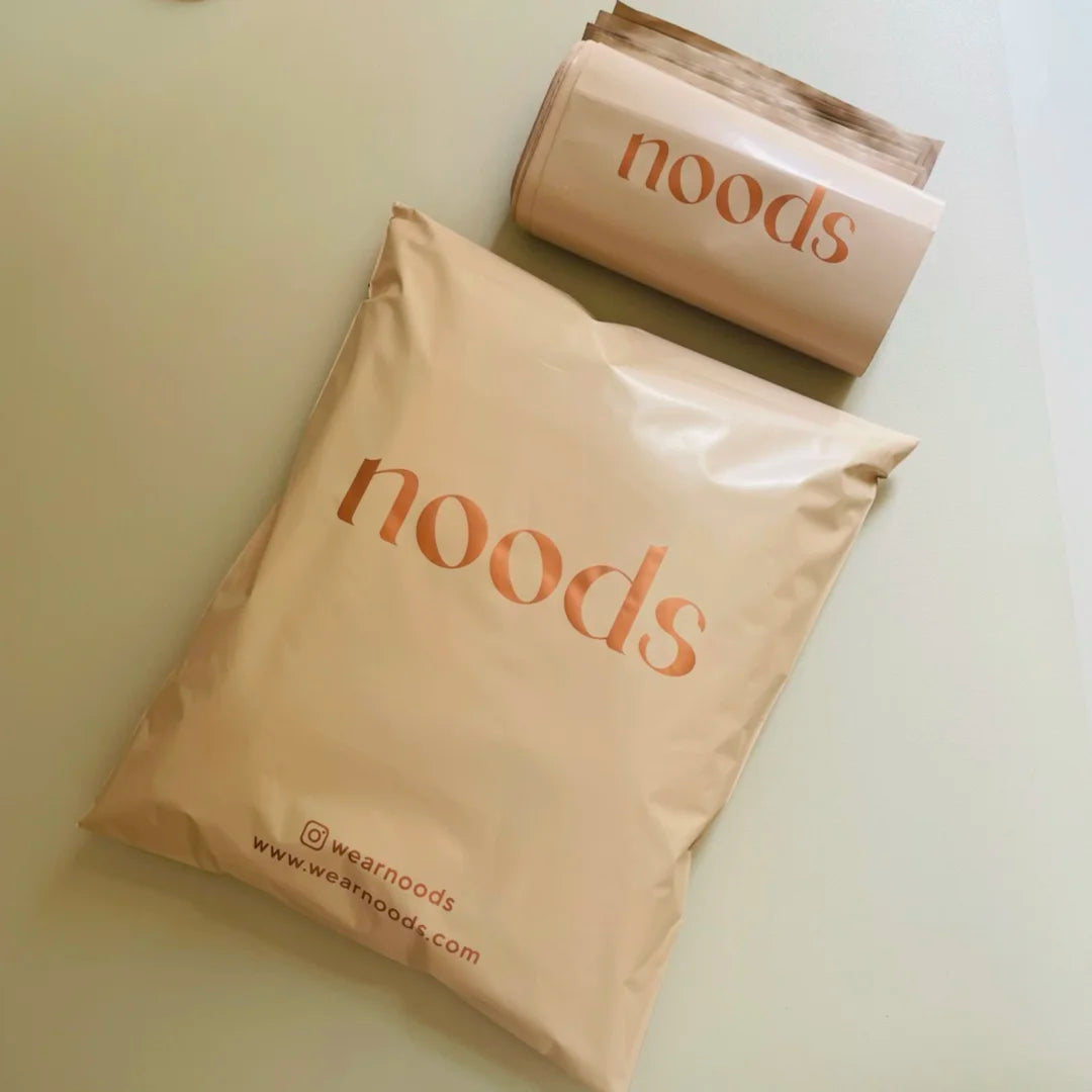 Tan poly mailer bag with “hoods” logo and wwwwearnoods.com text on front.