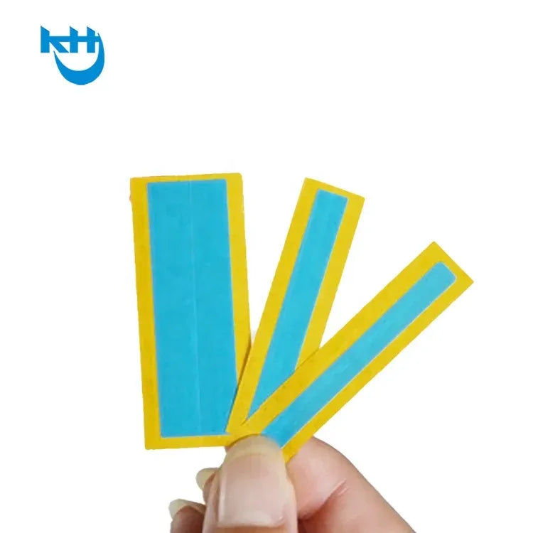 Hand holding yellow splice tape strips with blue center lines