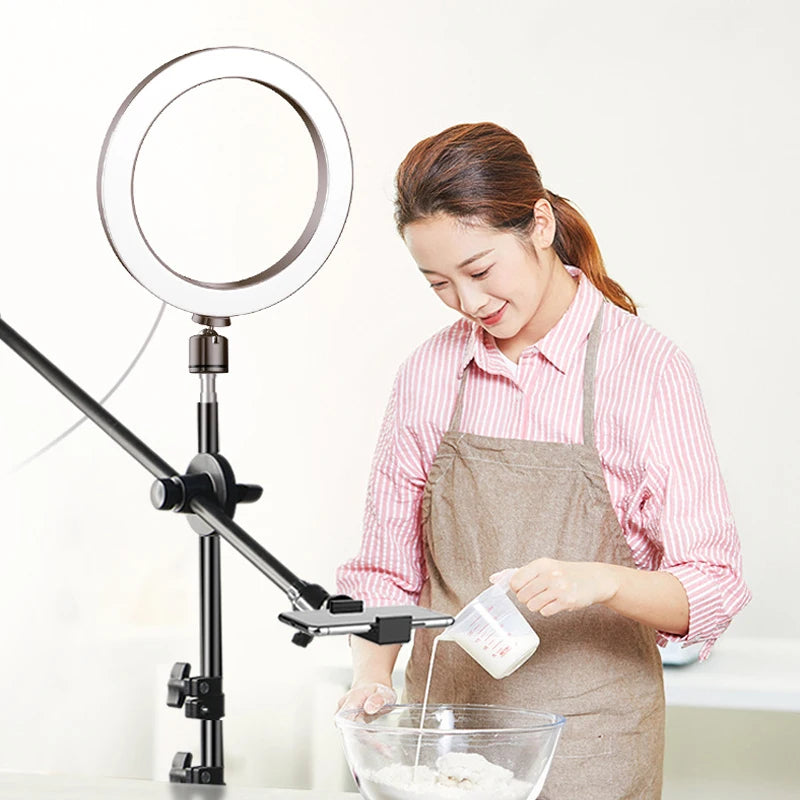 Round LED ring light with adjustable black metal stand and phone holder for overhead cooking videos and content