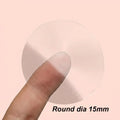 Clear round vinyl label sticker, 15mm diameter, held by fingertip