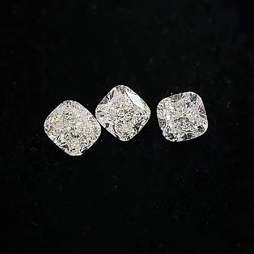 Three cushion-cut lab diamonds, faceted and reflective