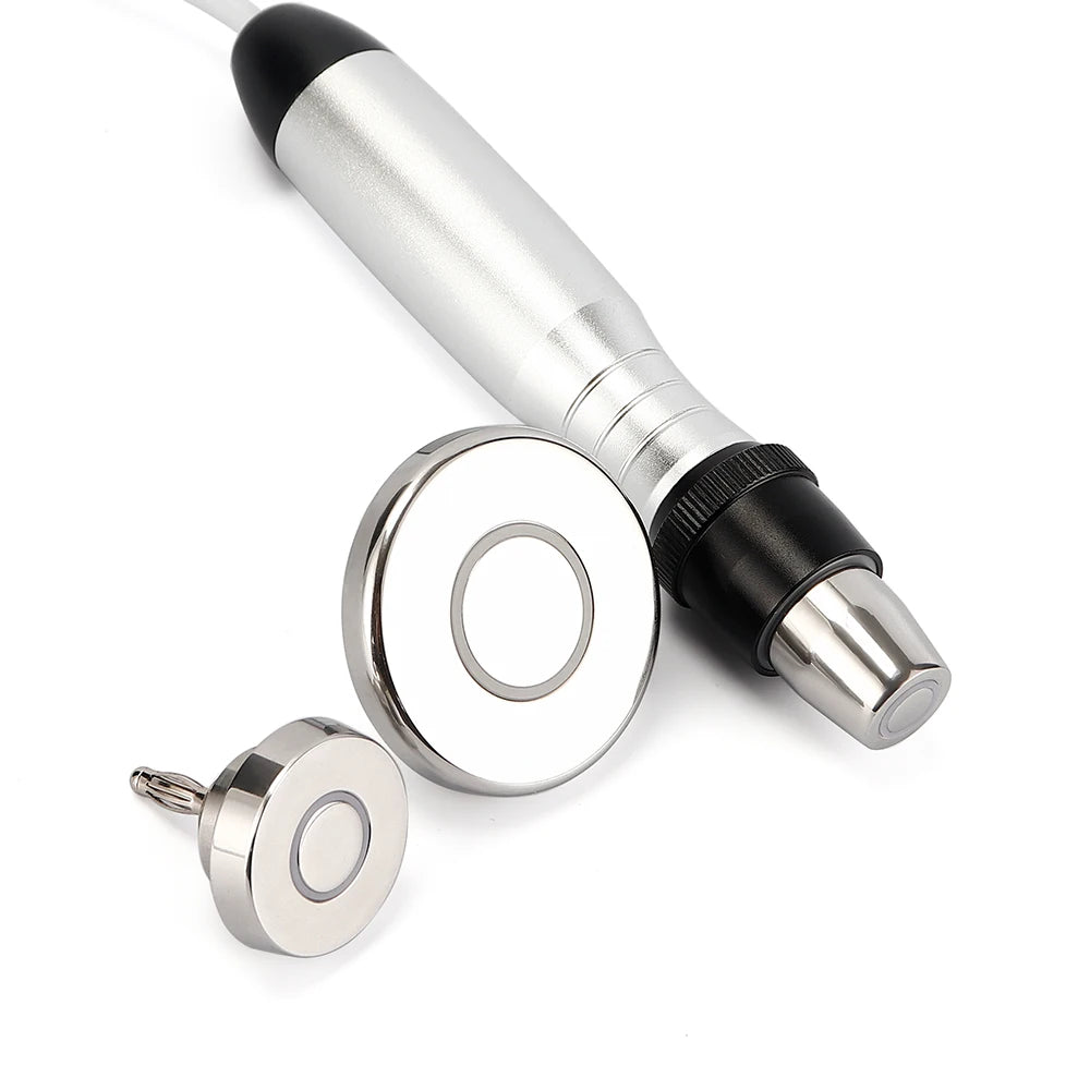 Silver RF beauty device with handle and two round, metallic interchangeable treatment heads on a white background.