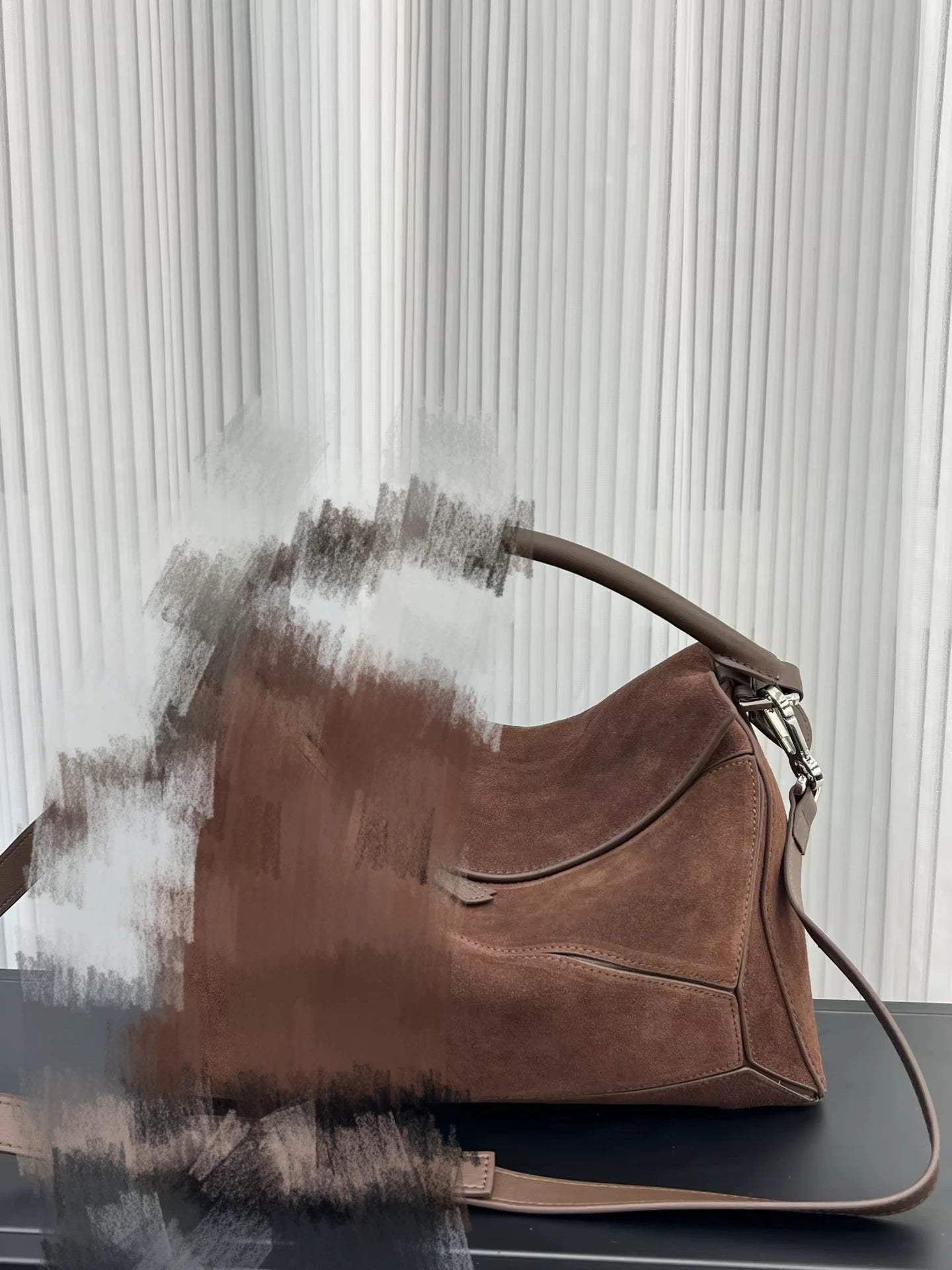Luxury brown suede designer crossbody handbag with structured leather handle and shoulder strap.