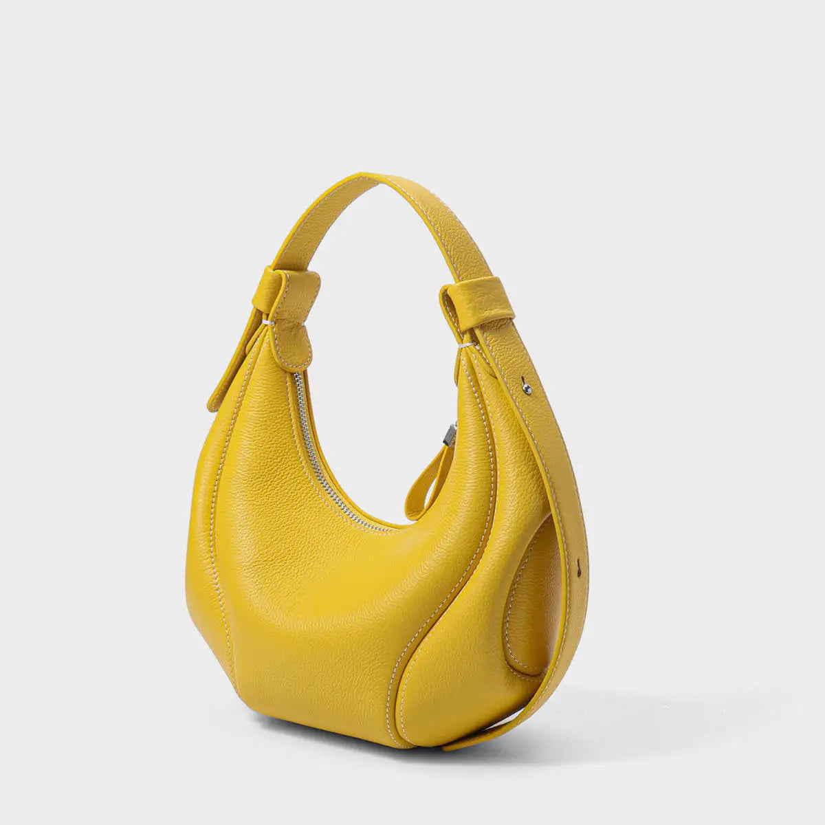 Yellow half moon leather handbag with pebbled texture, silver zip closure, and structural designer shoulder strap.
