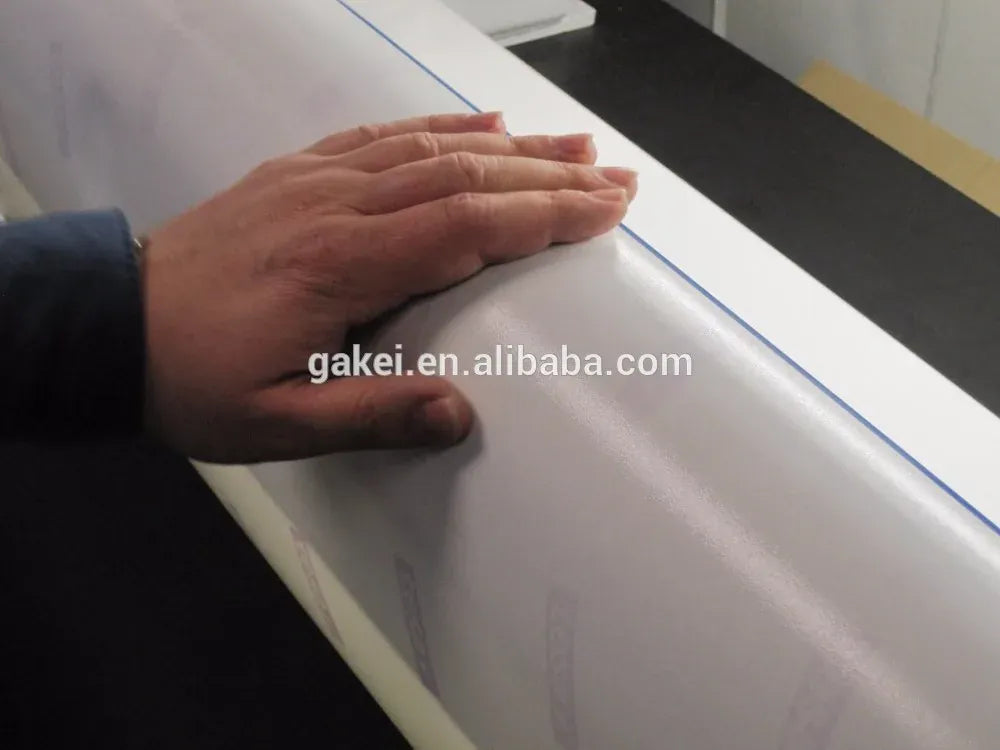 Hand smoothing masking tape over a smooth surface