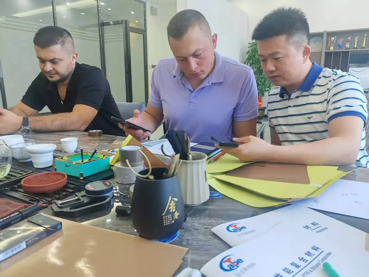 Heat-resistant tape team working at a table with papers, tools, and supplies