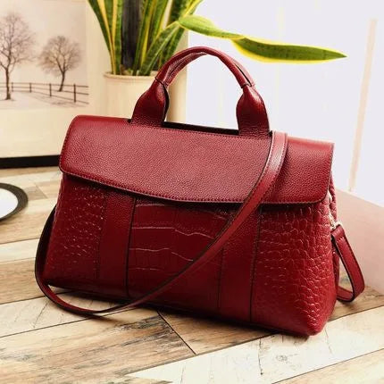 Red genuine leather designer crossbody handbag with crocodile skin texture, top handle, and flap closure.