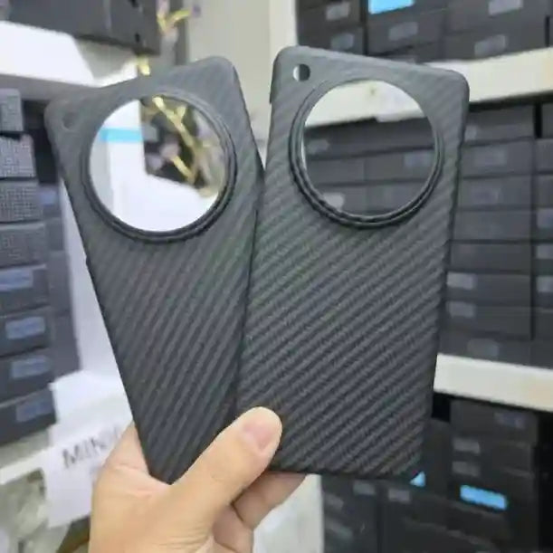 Black carbon fiber texture phone case with a large circular cutout for the camera lens.