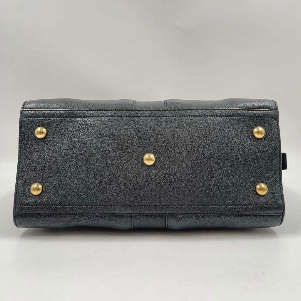 Black genuine leather pillow handbag with gold-tone metal feet. Retro unisex designer bag base.