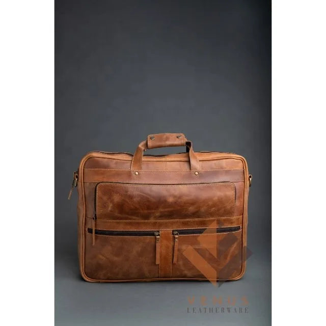 Tan genuine leather business briefcase with dual front zip pockets, top handles, and crossbody messenger strap.