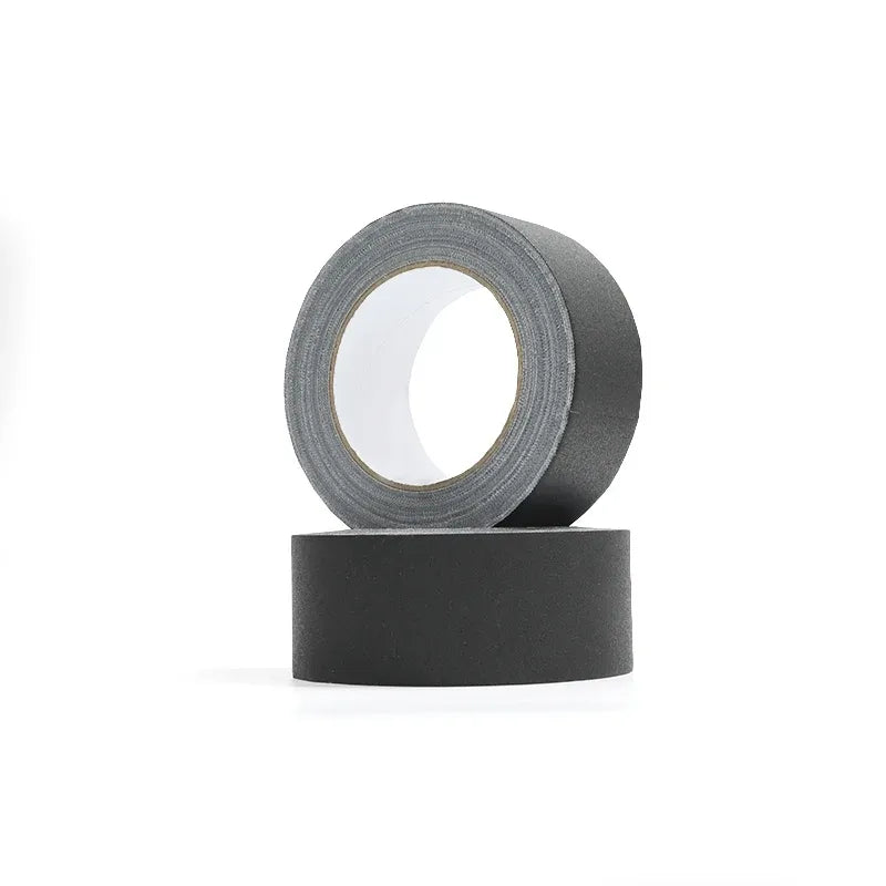 Black matte gaffer tape roll with visible light gray adhesive core