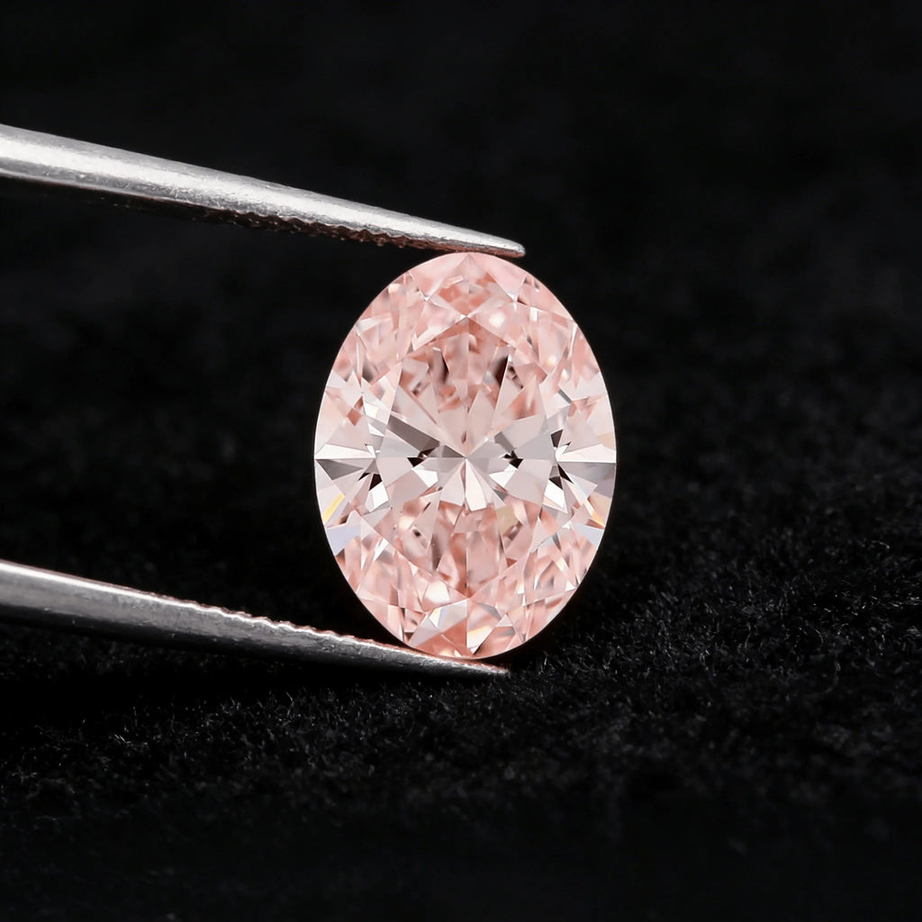 Oval fancy pink lab-grown diamond in tweezers with face-up sparkle