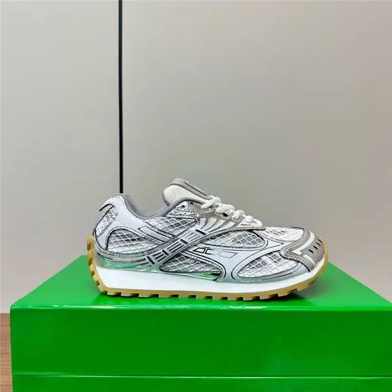 Luxury designer men's sneakers in metallic silver genuine leather with mesh panels, white midsole, and gum rubber sole.