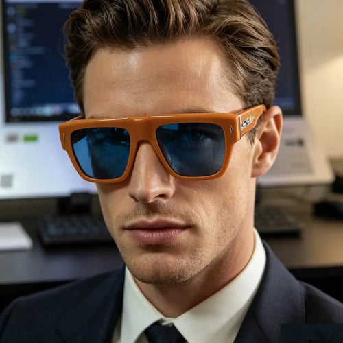 Luxury square orange acetate sunglasses with blue tinted lenses worn by a man in a formal suit.