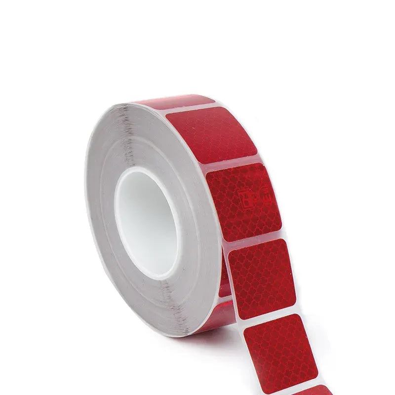 Reflective road safety tape roll, red strip with inset reflective squares pattern