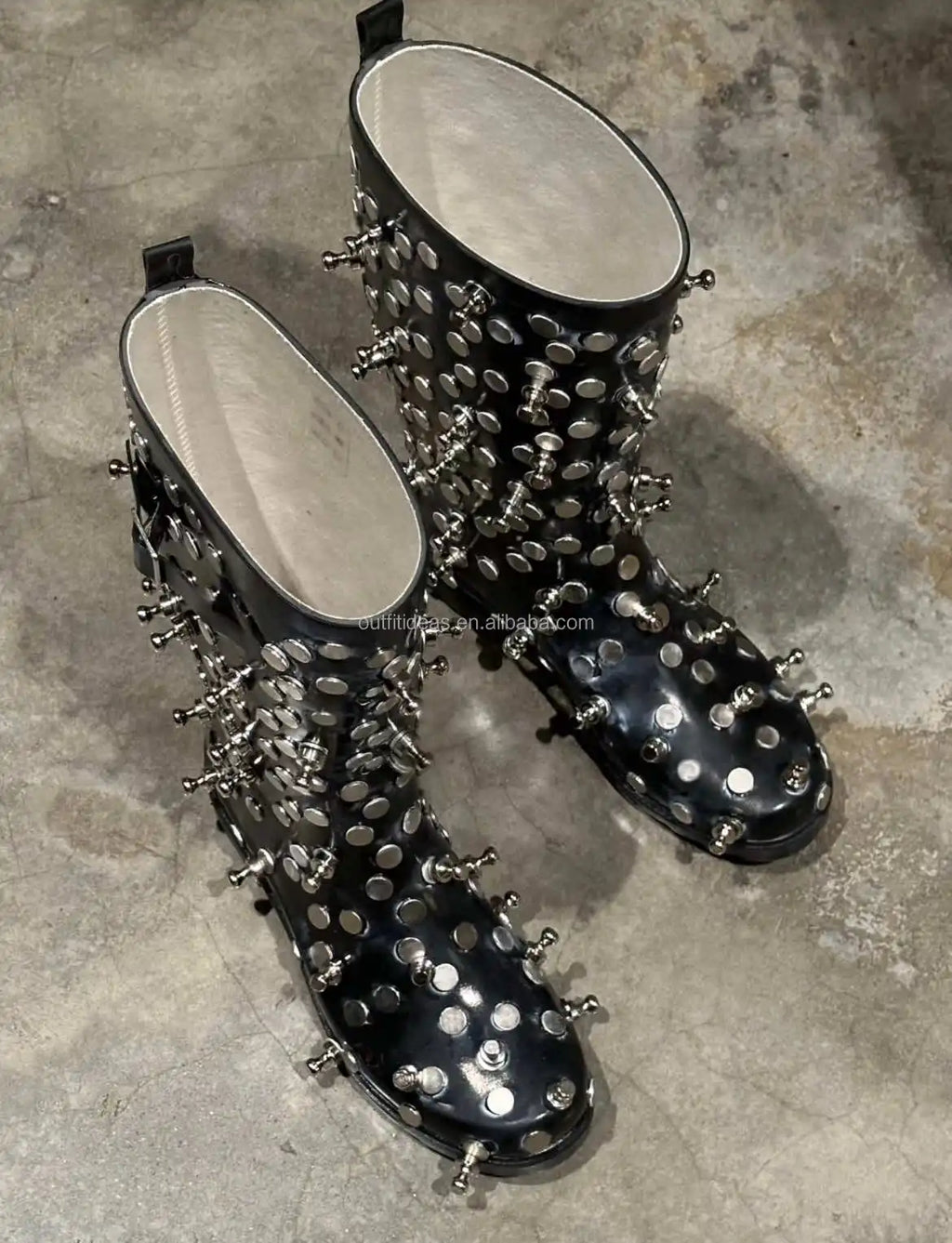 Black patent leather mid-calf boots with silver metal stud embellishments and chunky lug soles.