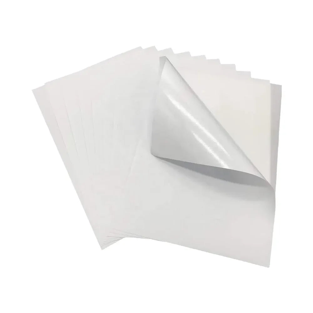 Pack of matte white self-adhesive sticker paper sheets, partially curled