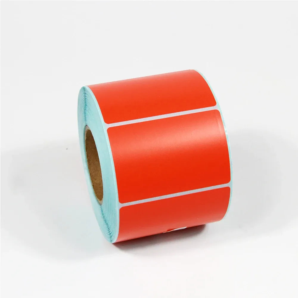 Red thermal label paper roll with rectangular label outlines on the tape.
