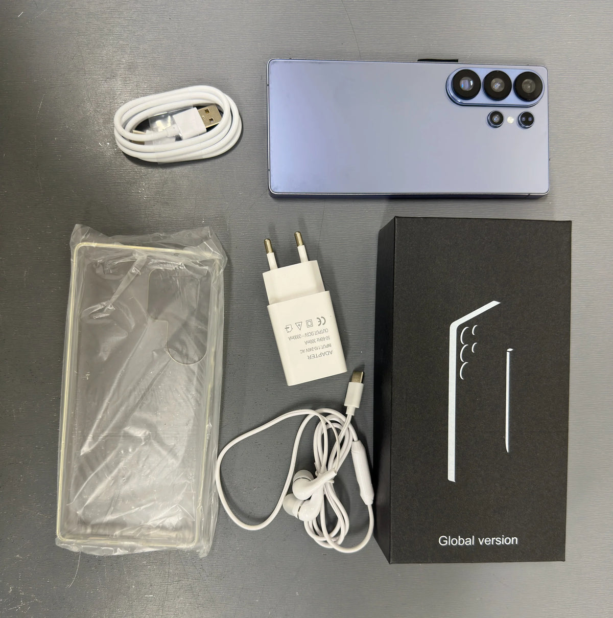 Unlocked blue smartphone with triple rear cameras, charging cable, charger, and box