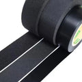 Close-up of black wire harness tape roll and textured fabric surface