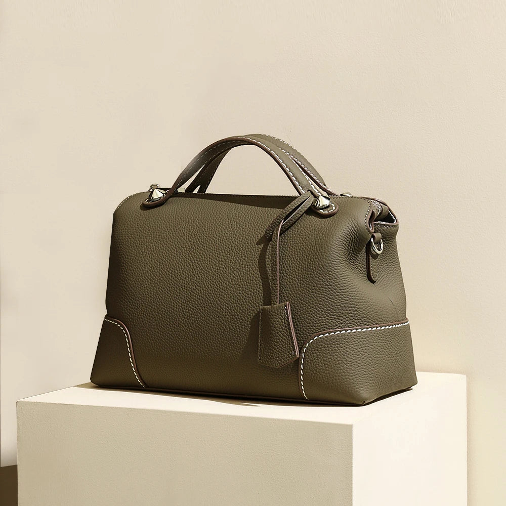 Olive green top-grain cowhide leather designer handbag with contrast stitching, silver hardware, and structured handle.
