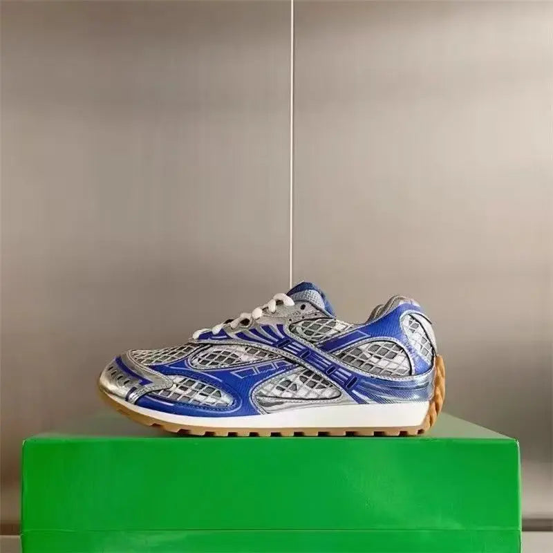 Luxury designer men's sneakers in blue and silver, featuring a mesh-leather mix, white laces, and a gum rubber sole.