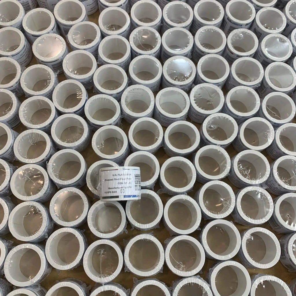 Bulk pack of circular self-adhesive stamps with gray backing in small rolls