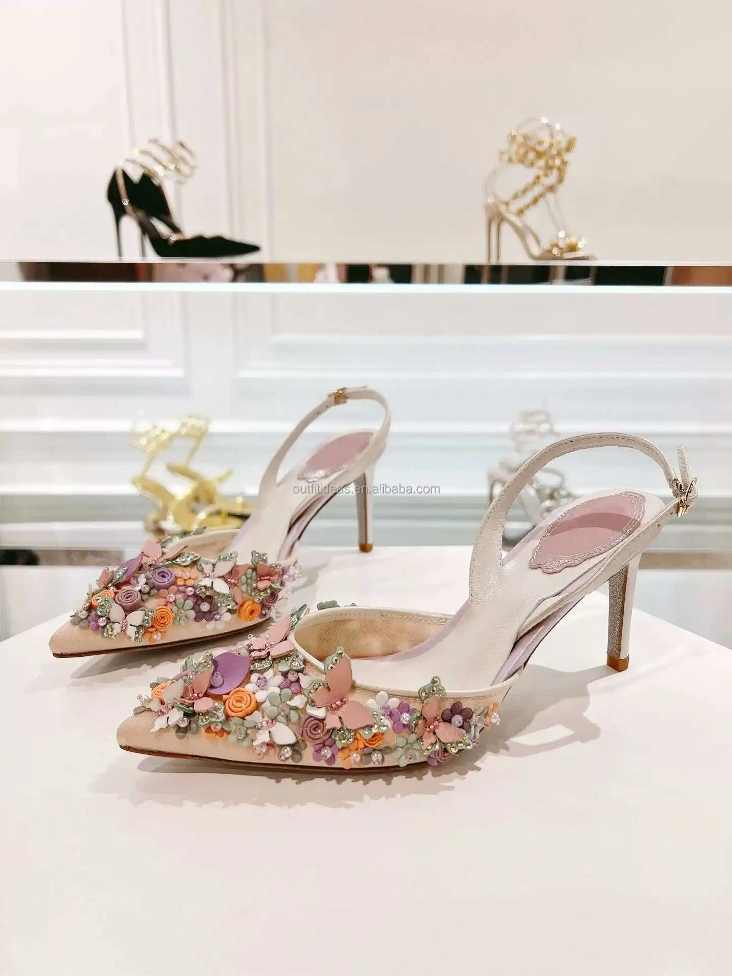 Beige satin slingback stiletto heels with 3D floral butterfly embellishments for bridal or luxury evening wear.