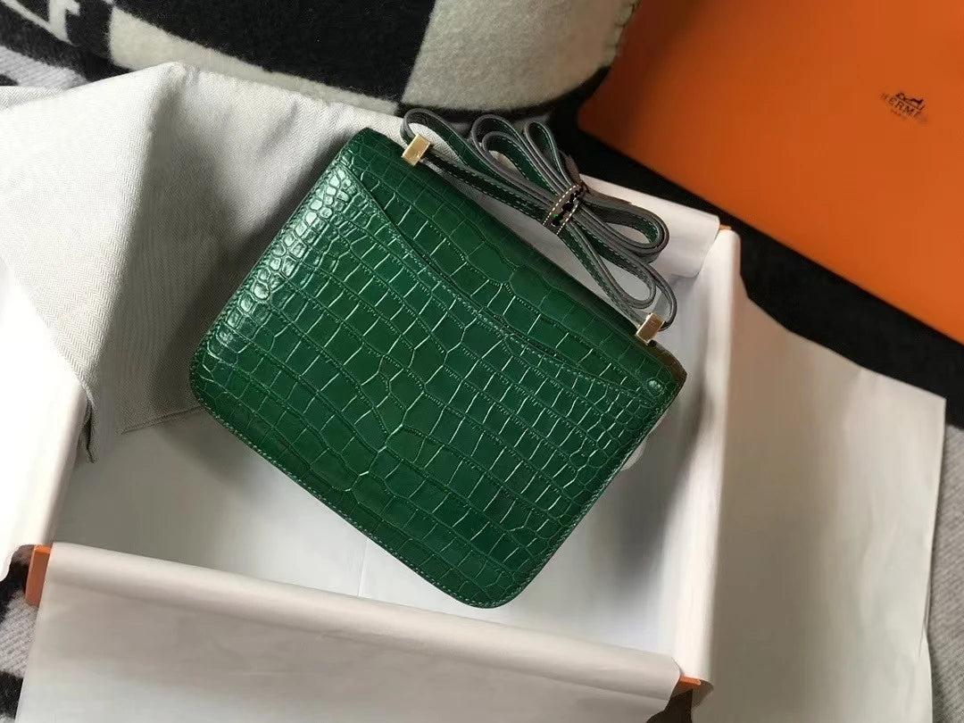Emerald green alligator-pattern leather trunk shoulder bag with gold hardware in a branded gift box.