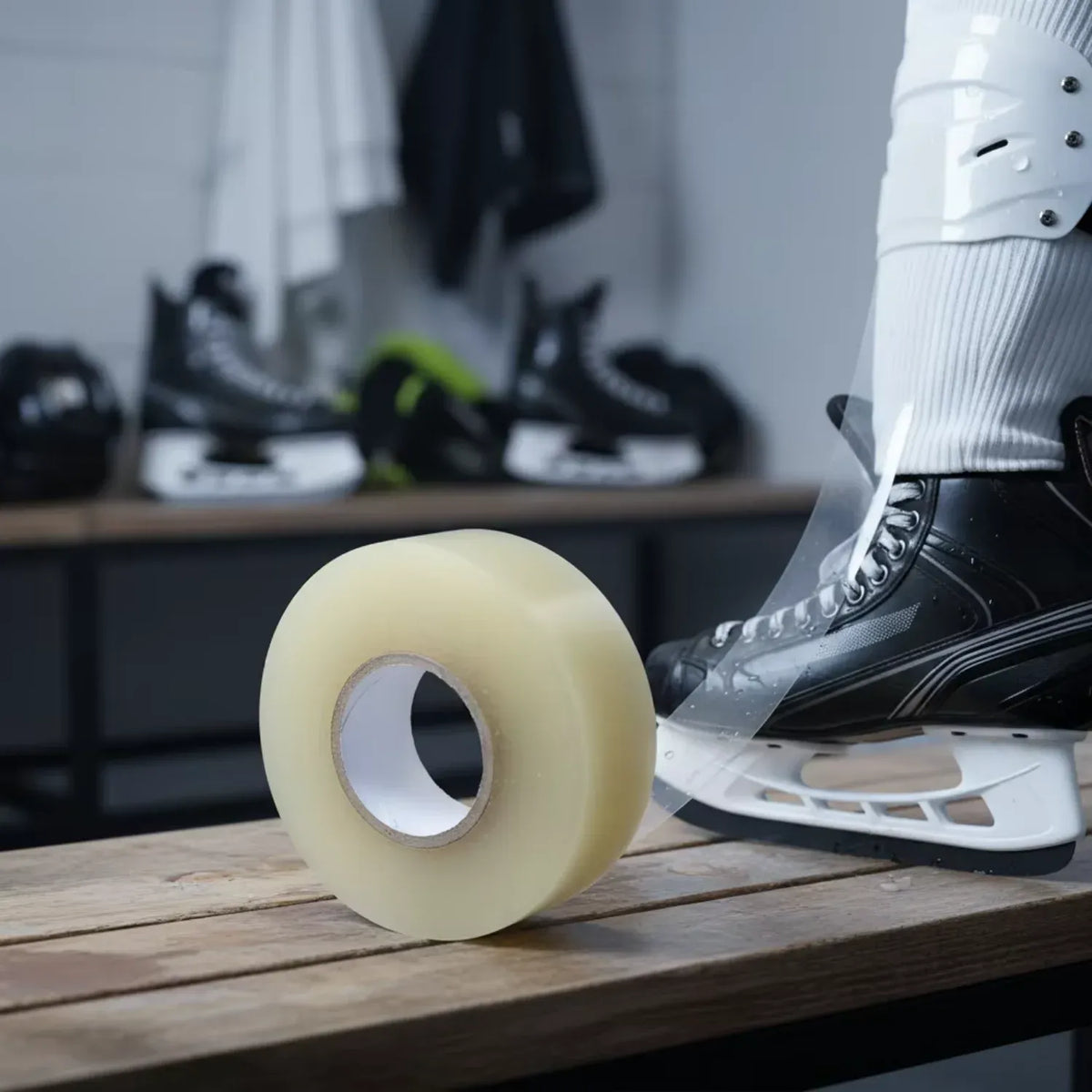 Pale yellow sports tape roll on a bench beside ice skates
