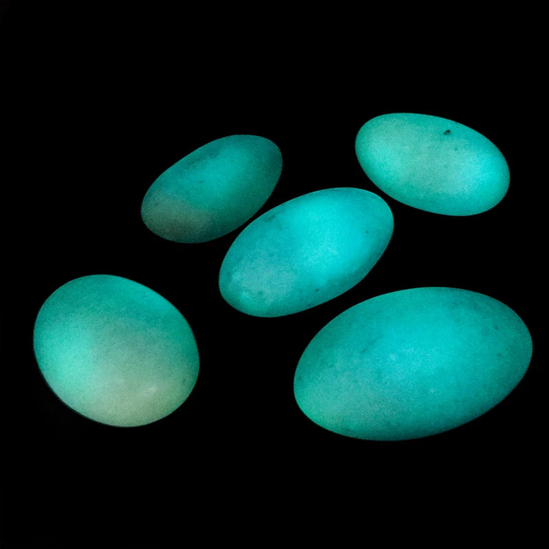 Bright green glowing oval crystal pebbles, luminous stones for landscape decor