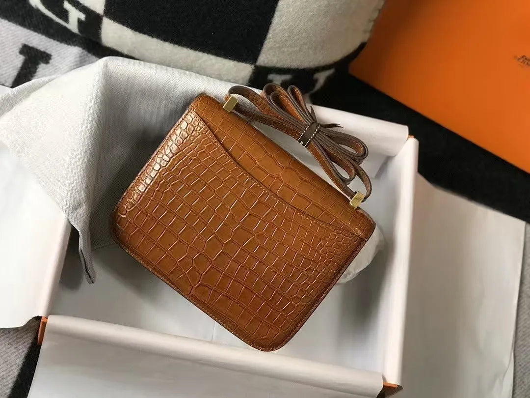 Brown genuine leather shoulder bag, alligator pattern, compact trunk-style silhouette with gold-tone hardware in gift box.