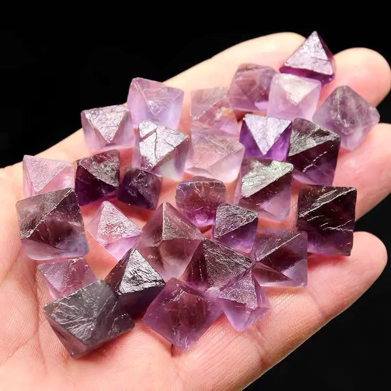 Purple rough crystal octahedra cluster in hand, multi-faceted points, silver-toned facets
