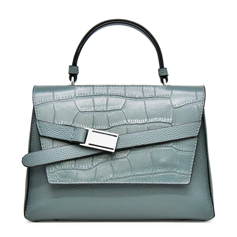 Blue-grey genuine leather designer handbag with a crocodile texture, top handle, and silver buckle strap detail.