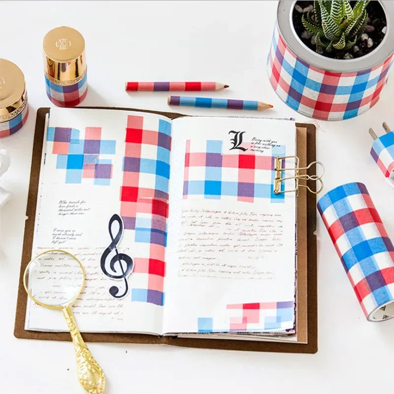 Decorative masking tape strips in red and blue plaid on an open journal