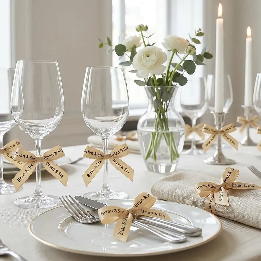 Champagne gold satin ribbon streamers on table with place cards and wine glasses