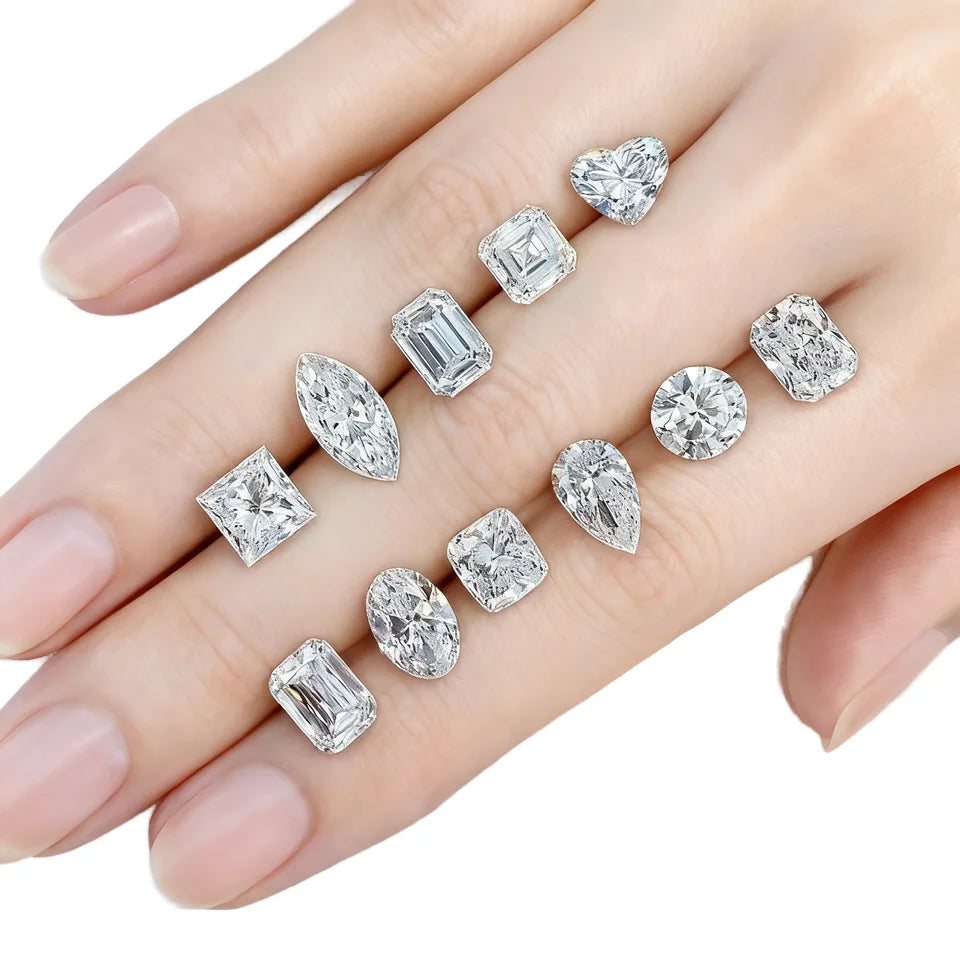 Loose lab-grown diamonds on open hand, showing several cuts