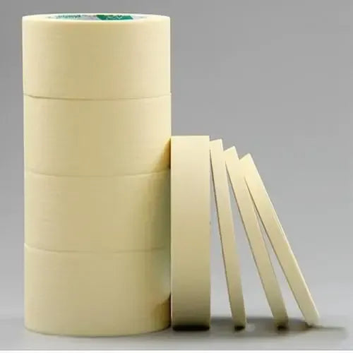 Light yellow adhesive tape rolls with several cut strips laid beside the roll