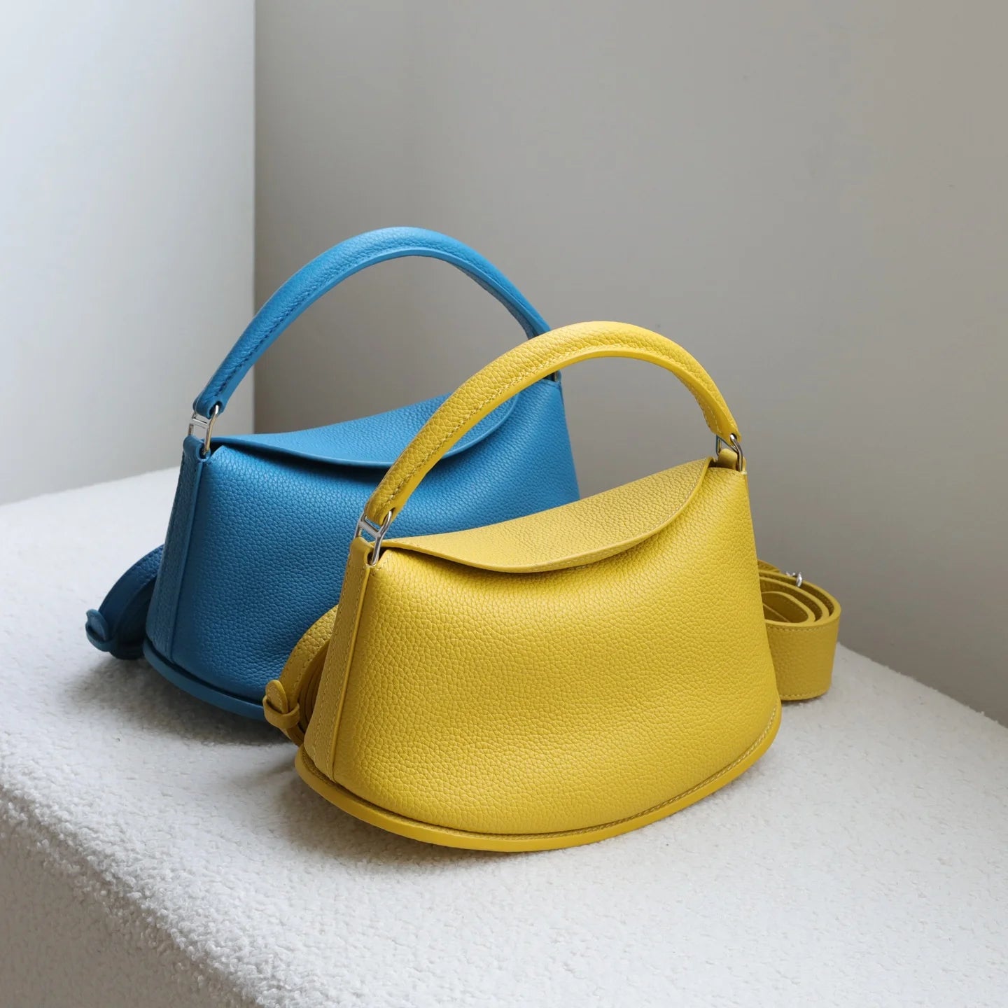 Yellow and blue luxury cowhide leather handbag set, pebble-grain pillow shape with magnetic closure and dual straps.