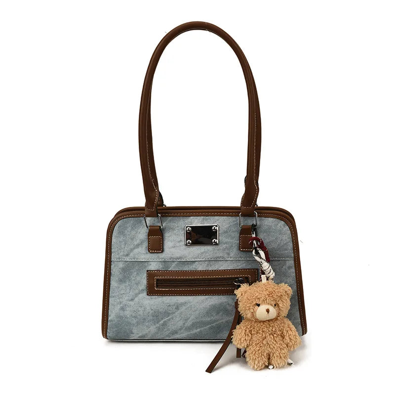 Blue and brown soft leather tote bag with long handles, front zip pocket, and cute teddy bear keychain charm.