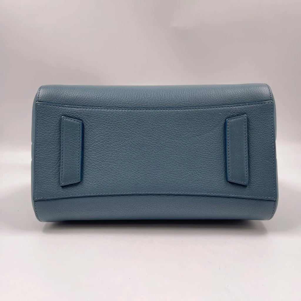 Blue pebbled genuine leather designer handbag, rectangular base with structured side tabs. Classic luxury tote style.