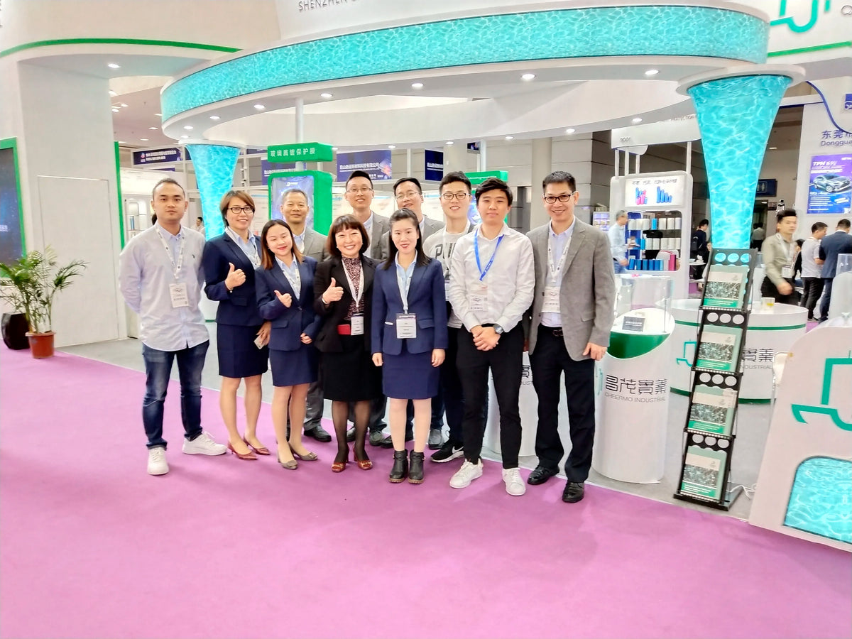 Team standing at a trade show booth displaying a blue product display stand