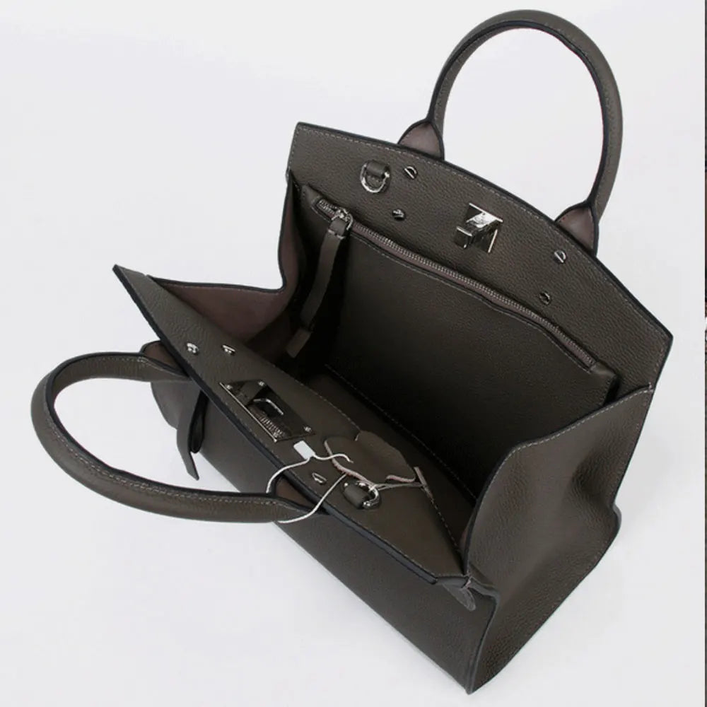 Taupe genuine leather tote trunk bag with top handles, silver hardware, and interior zip pocket for women.
