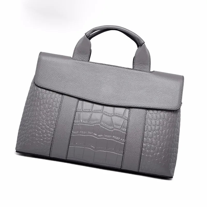 Grey genuine leather designer handbag with crocodile embossed texture, top handle, and elegant flap-over closure.