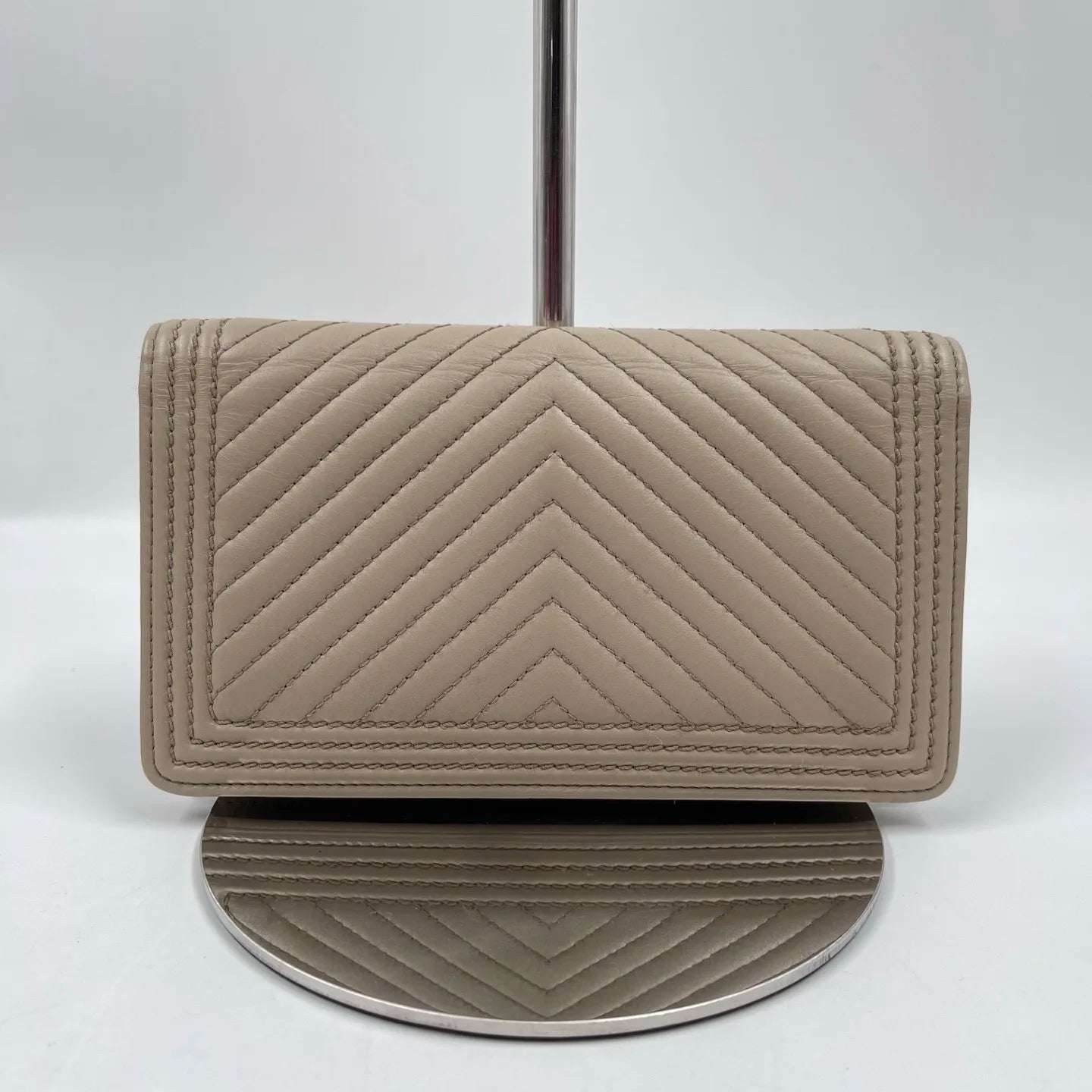 Elegant pre-owned designer tan wallet in genuine leather with chevron quilted stitching. Luxury fashion accessory.