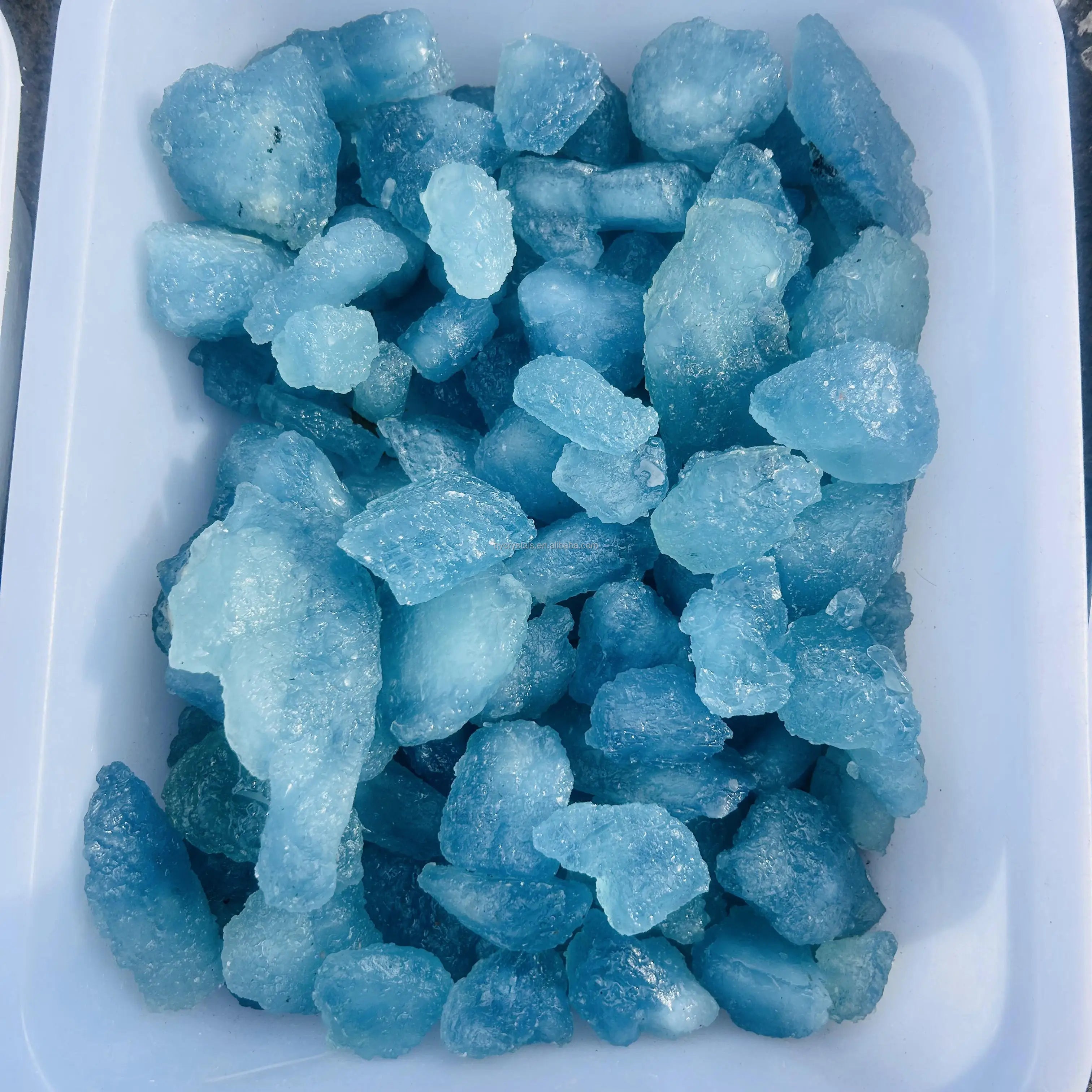 Tray of sky blue aquamarine rough crystal stones, assorted shapes